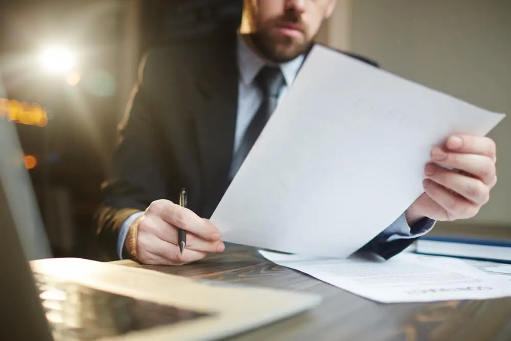 lawyer reading a legal document with a pen in hand