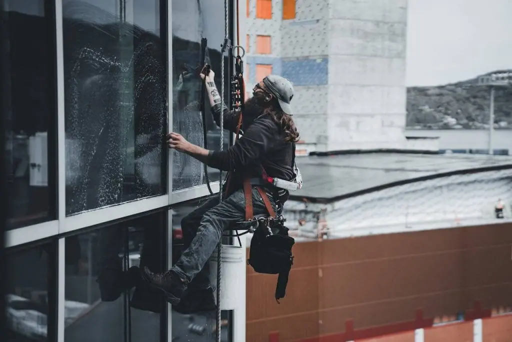 professional window cleaner cleaning high rise windows outside