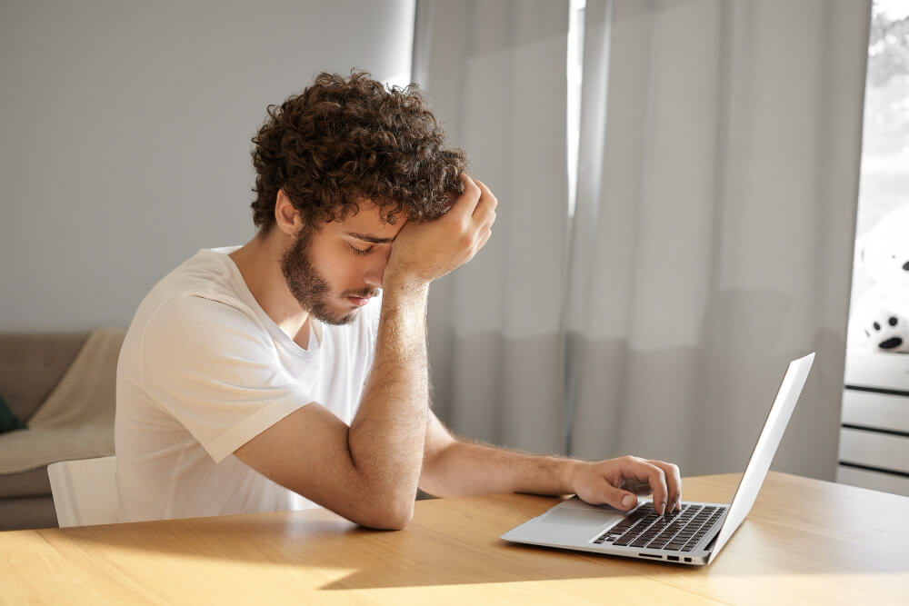 frustrated person working on laptop