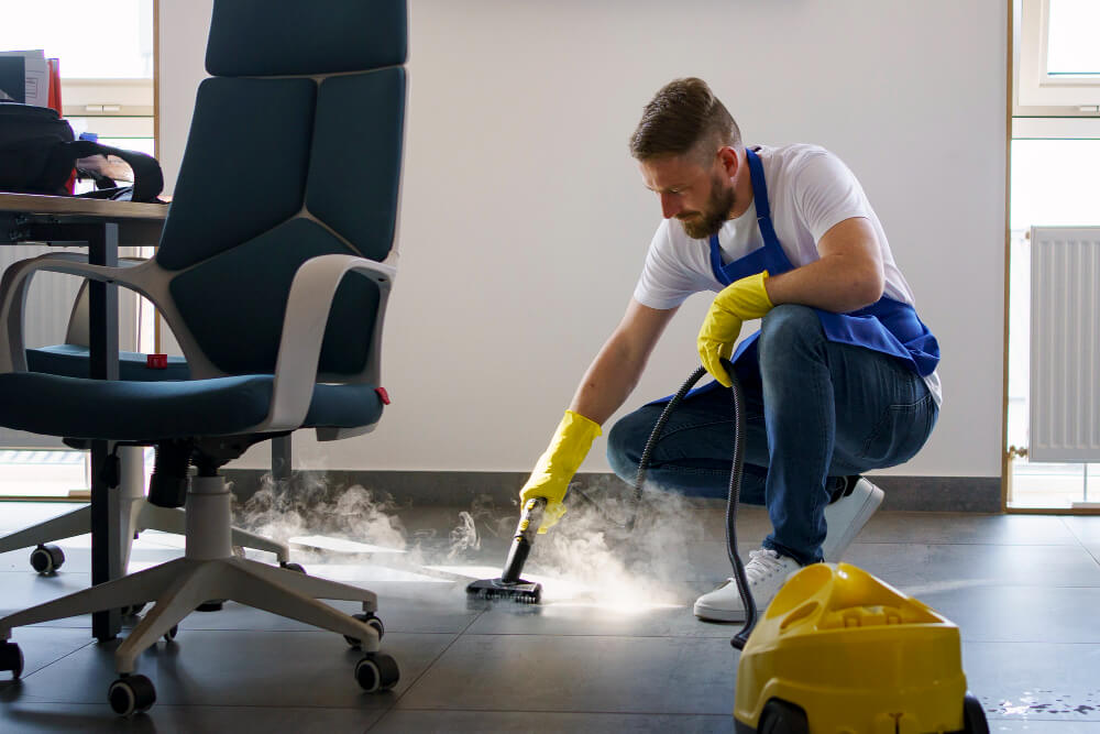 man using steam cleaner to clean office flooring