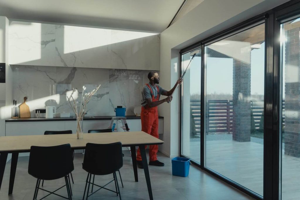 man cleaning building windows indoors