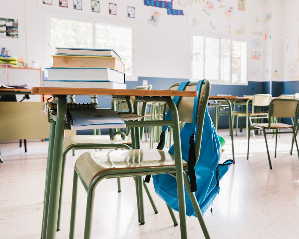 school classroom with blue backpack hanging on one of the chair rests school classroom with blue backpack hanging on one of the chair rests