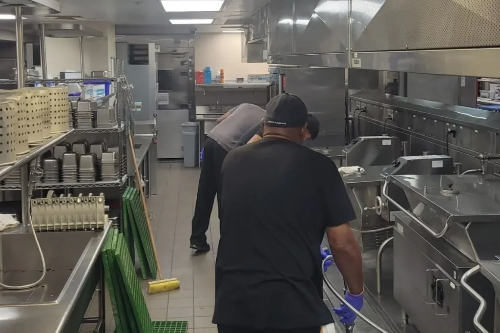 Two professional cleaners deep cleaning commercial kitchen in Dallas Fort Worth - Restaurant cleaning services
