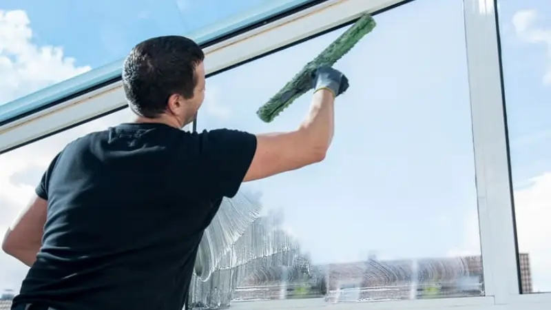 Cleaning technician cleaning windows in Arlington TX office building