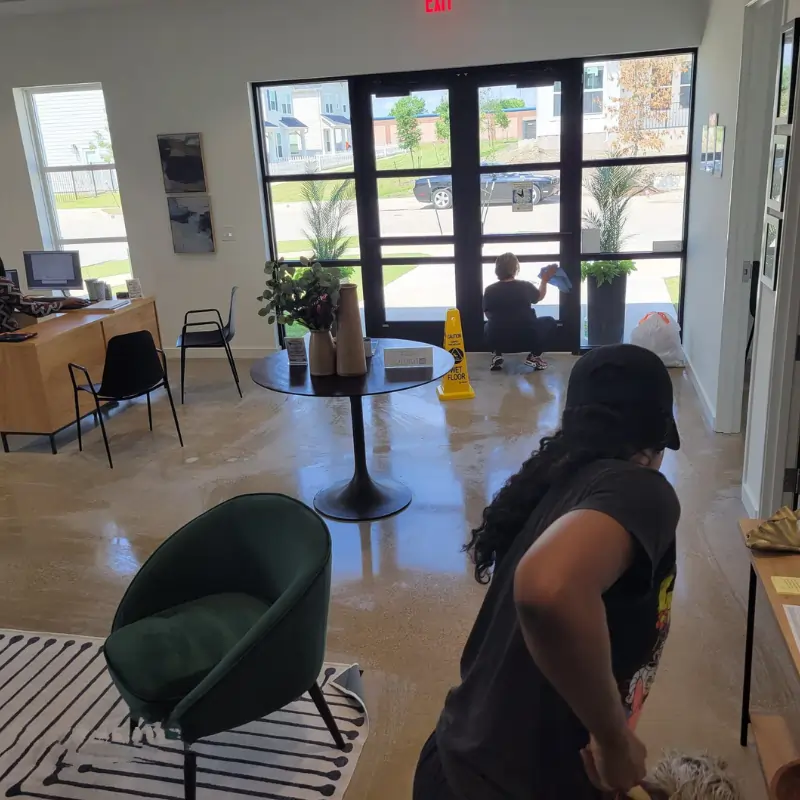 Cleaning crew cleaning floors and windows in office space